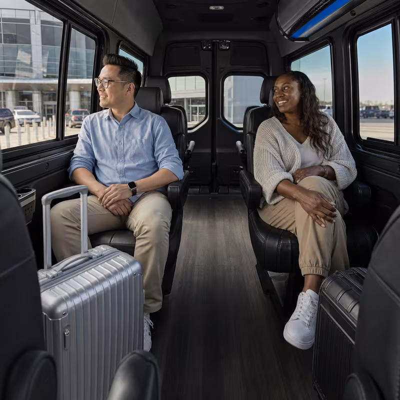 Passengers loading luggage while boarding an Fort Wayne group shuttle