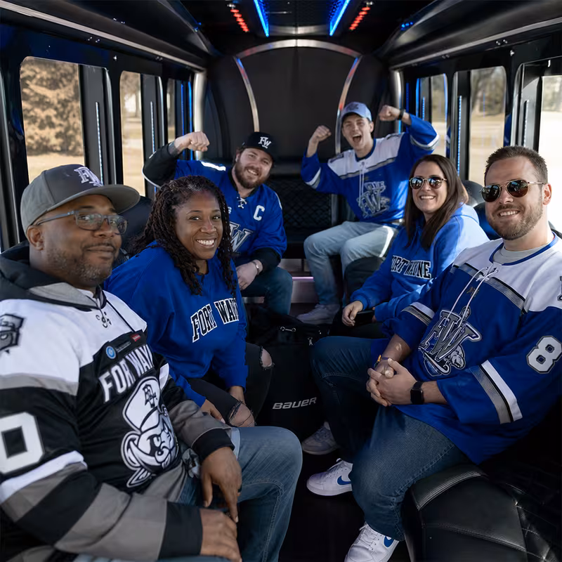 Group boarding a white charter bus for Sporting Event Transportation transportation in Fort Wayne